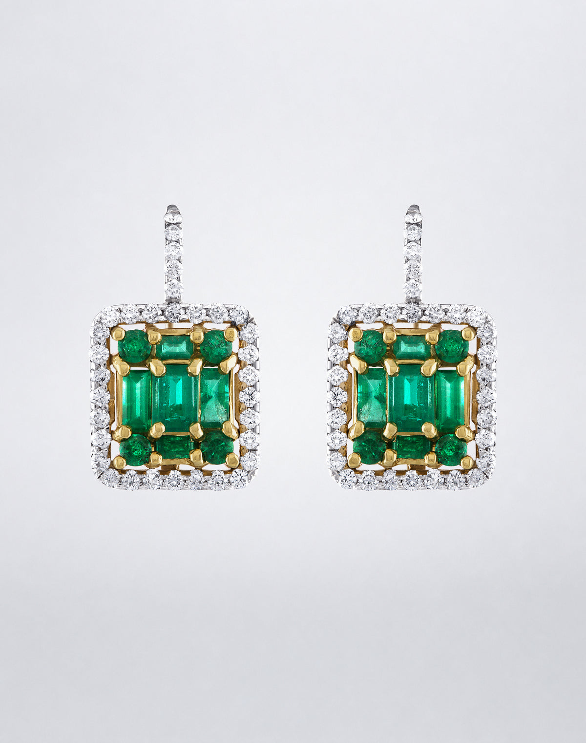 Mindi Mond New York Clarity³ Mega Two-Tone Emerald Halo Earrings, an enlarged emerald formation in 18K yellow gold framed by a diamond halo in 18K white gold