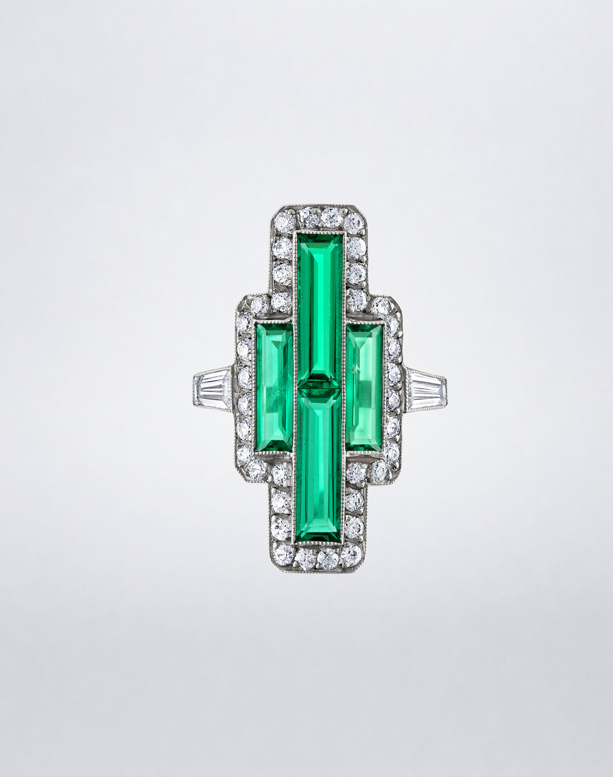 One-of-a-kind Colombian Emerald Tapered Baguette Pointer Ring featuring elongated emeralds framed by round diamonds with tapered baguette diamond side accents.