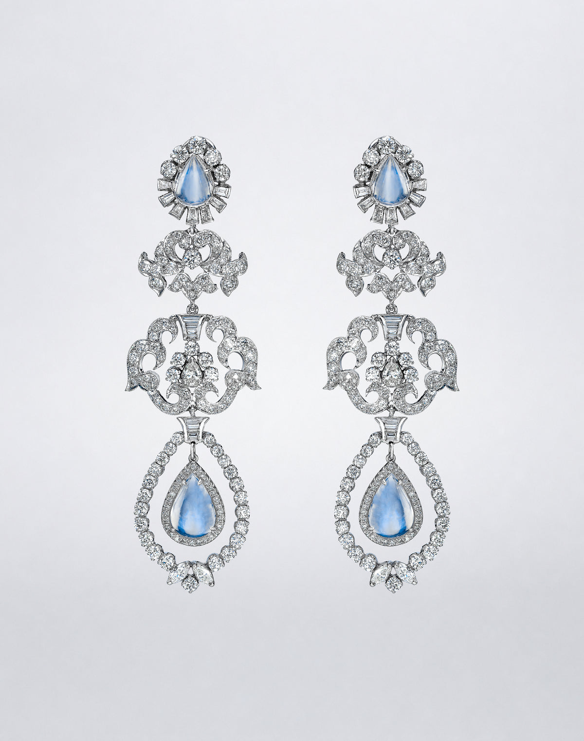 A pair of chandelier earrings featuring pear-shaped moonstones and diamonds in an ornate openwork drop design.