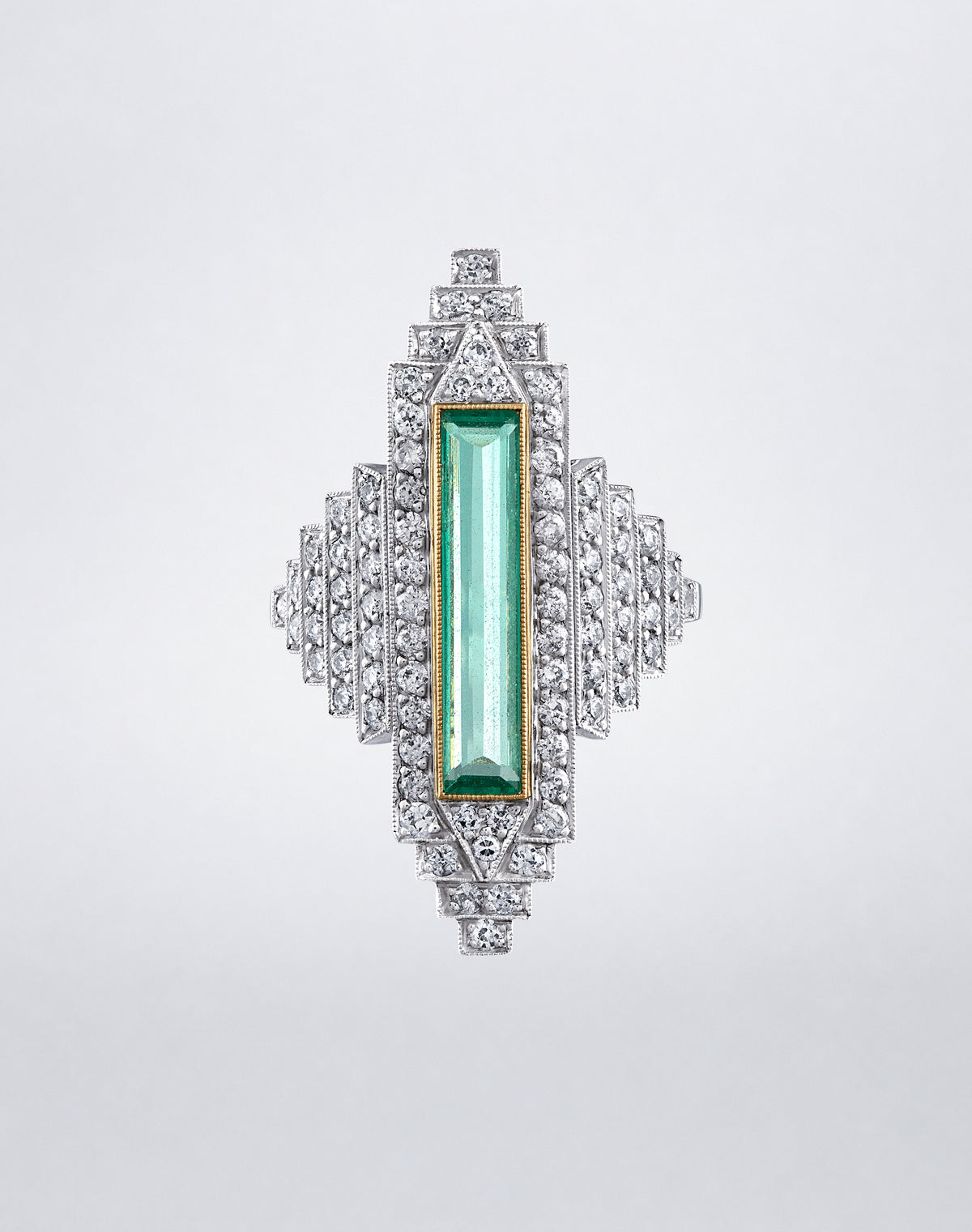 One-of-a-kind Emerald City Ring featuring an elongated emerald framed by stepped rows of round diamonds in a geometric Art Deco setting.