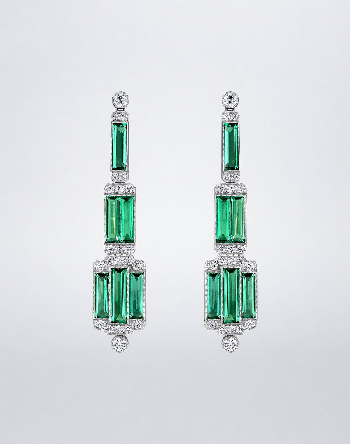 One-of-a-kind Towering Step Emerald Chandelier Earrings featuring elongated step-cut emeralds framed by diamonds in tiered geometric drops.