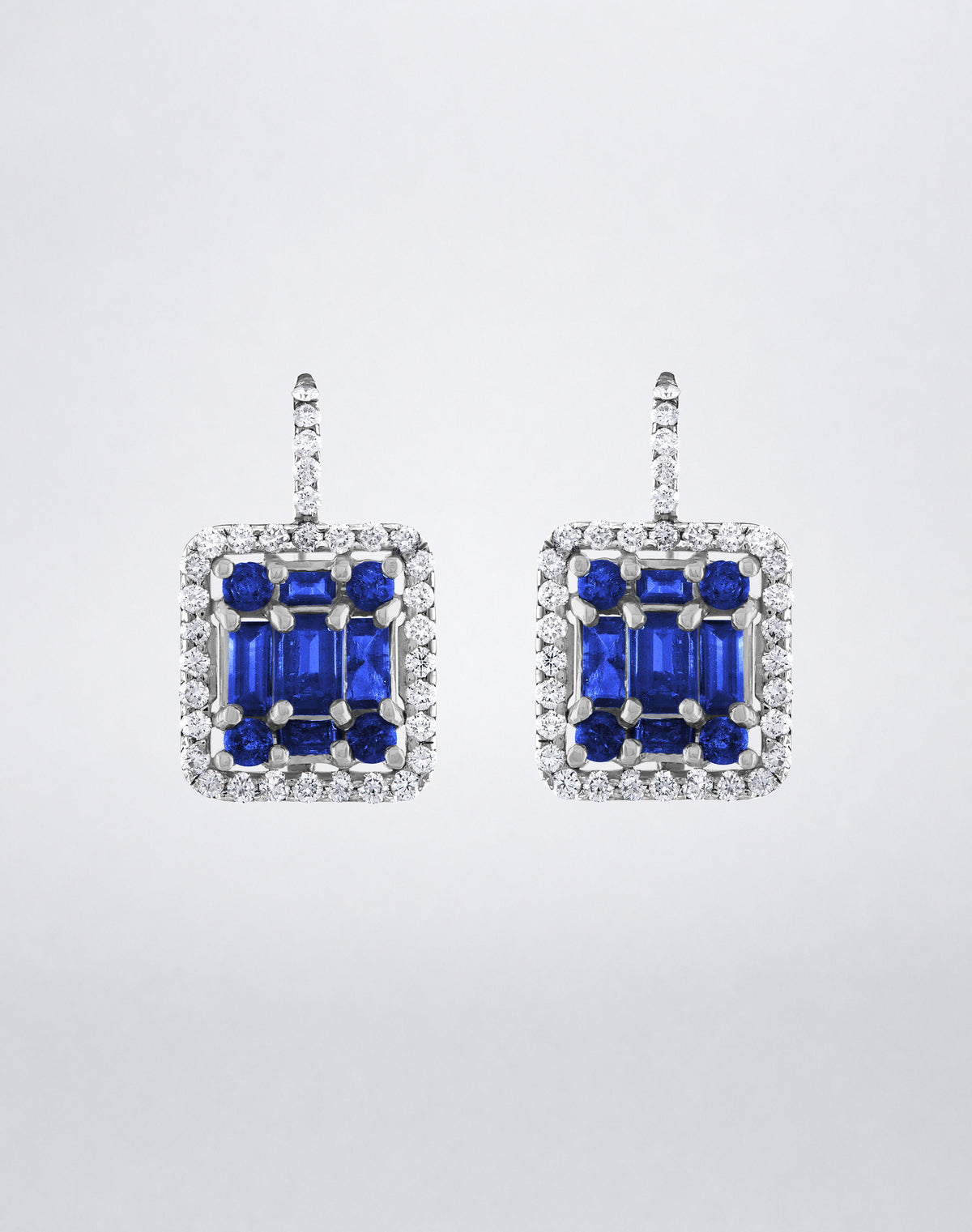 Mindi Mond New York Clarity³ Classic Sapphire Halo Earrings in 18K white gold, a nine-stone blue sapphire formation framed in a diamond halo on a pavé lever-back