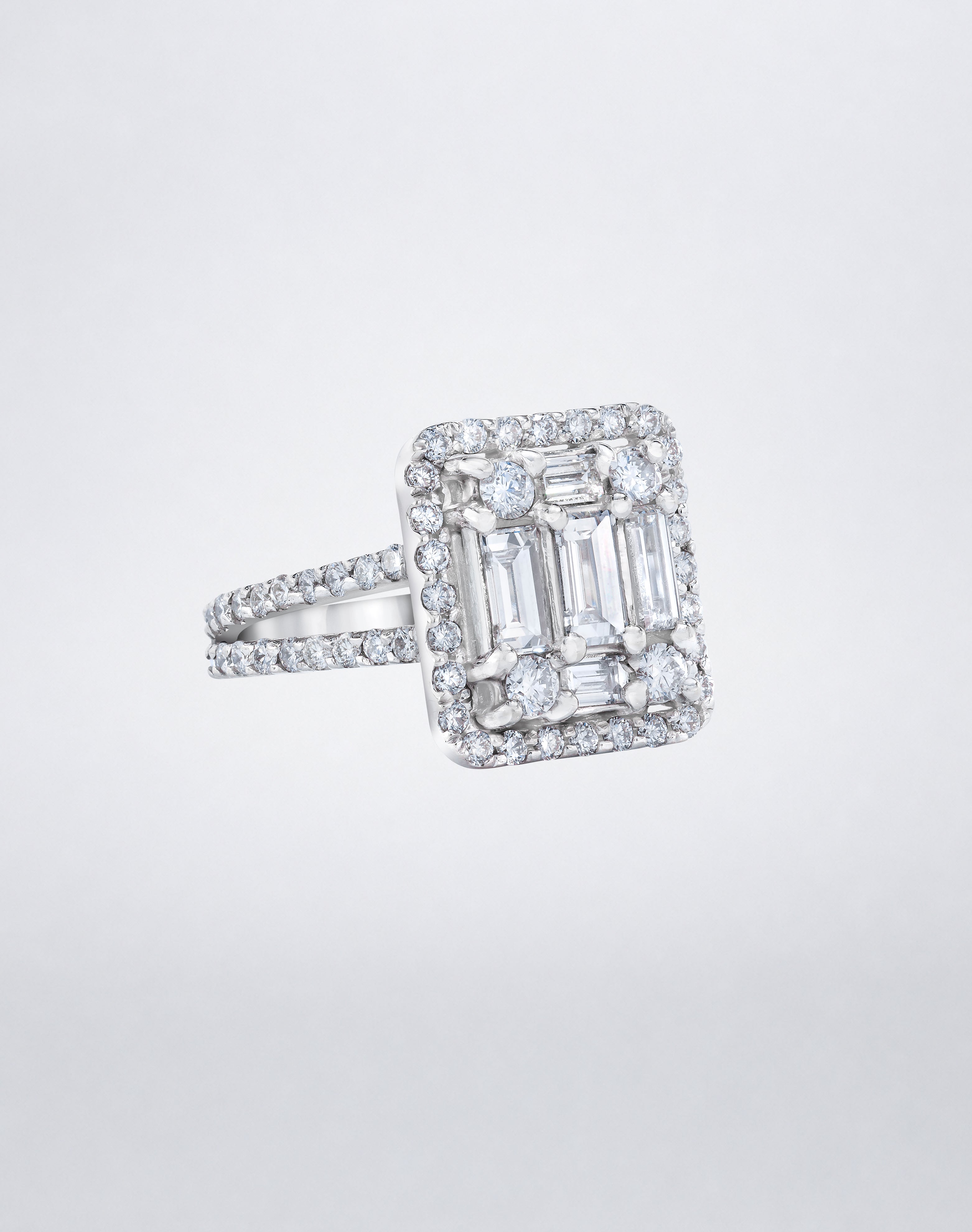 Mindi Mond New York's CLARITY³ Split-Shank Halo Ring in 18K white gold with a baguette diamond cluster and round diamond halo, side view