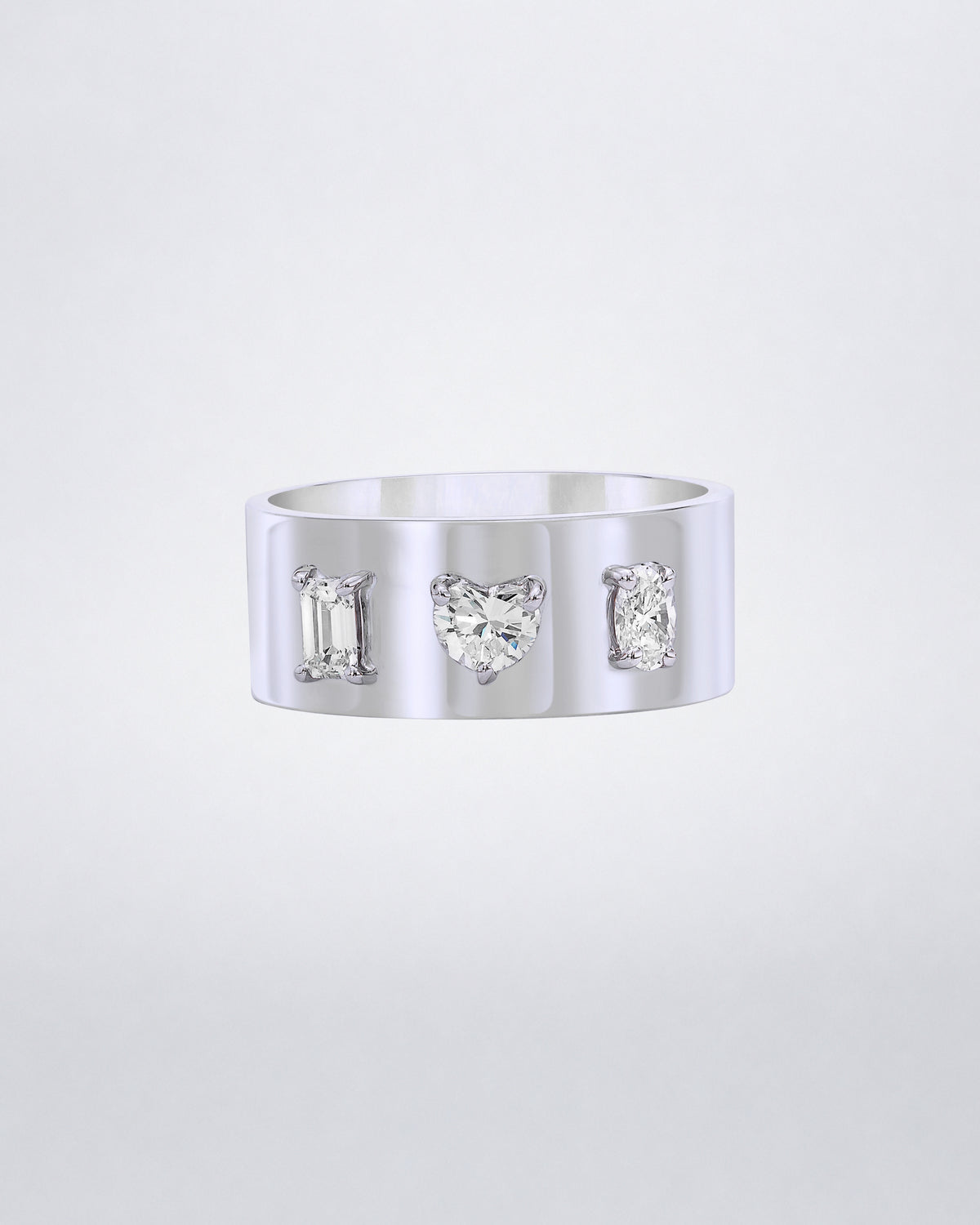 Mindi Mond New York Fancy Cut Cigar Band in 18K white gold, emerald, heart and oval-cut diamonds claw-set into a wide high-polish band