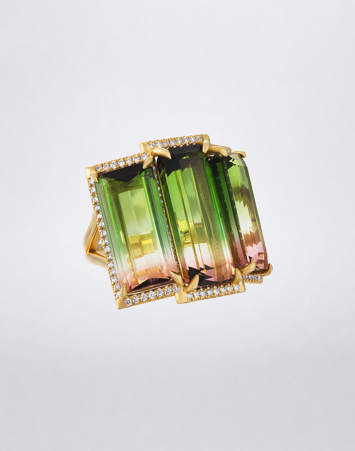 Angled view of the Mindi Mond New York Bi-Color Watermelon Tourmaline Ring with three elongated tourmalines and diamond detailing in 18K yellow gold.