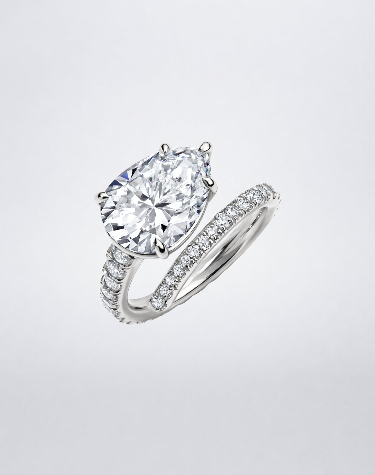 Angled view of the Mindi Mond New York Diamond Single Spiral Ring featuring a pear-shaped diamond and pavé diamond spiral in white gold.