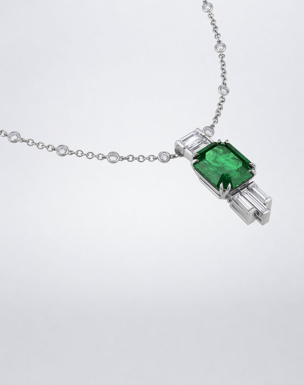 Angled view of the Mindi Mond New York Emerald and Diamond Joaillerie Pendant Necklace with emerald and baguette diamonds.