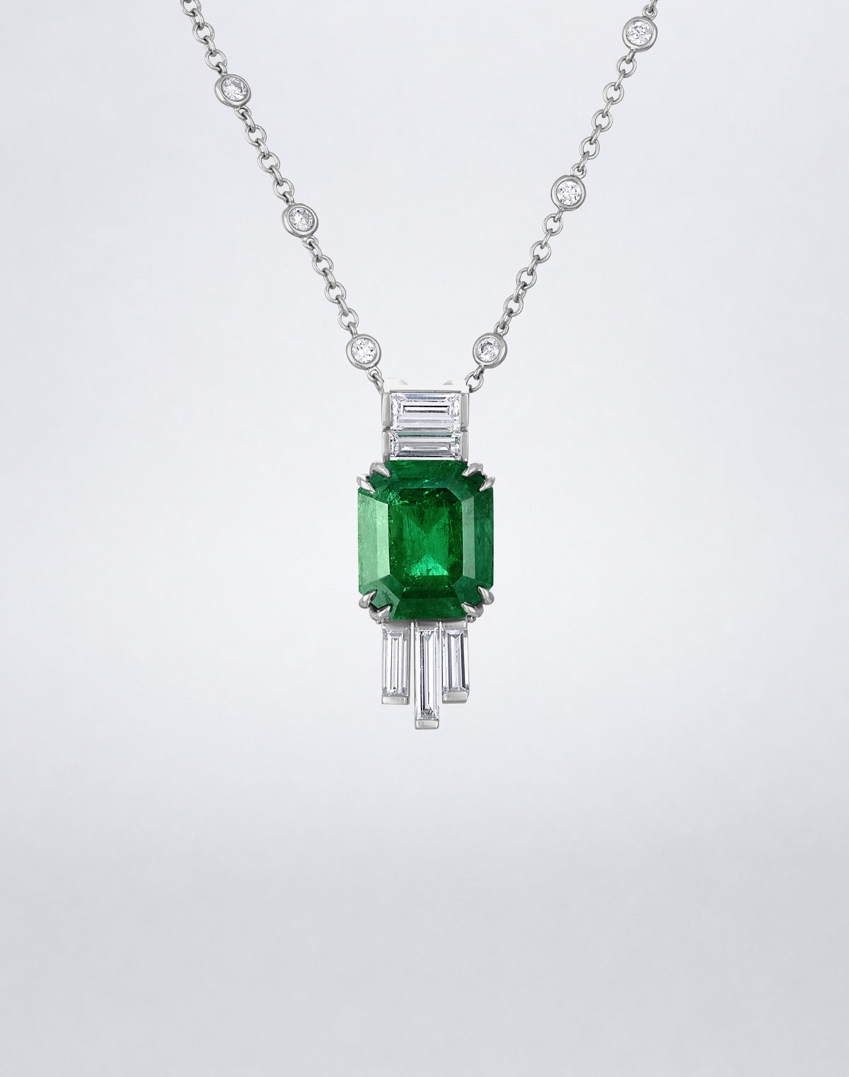 Close-up of an emerald-cut emerald framed by baguette diamonds on the Mindi Mond New York Joaillerie Pendant Necklace.