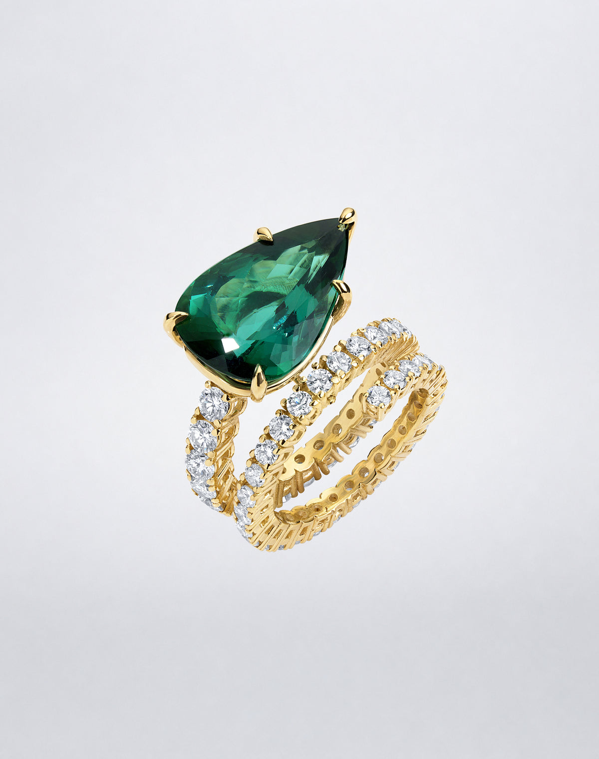 Angled view of Mindi Mond New York Green Tourmaline and Diamond Double Spiral Ring with pear-shaped tourmaline and pavé diamond bands.