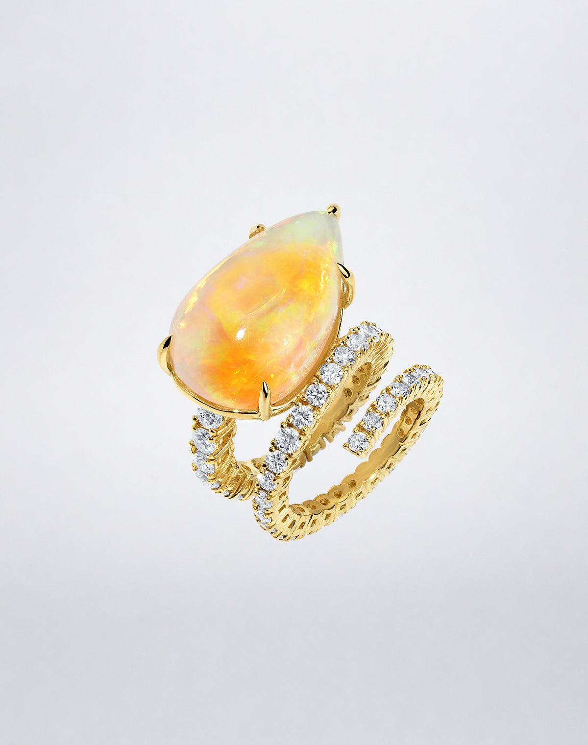 Angled view of the Mindi Mond New York Opal and Diamond Double Spiral Ring in 18K yellow gold with pavé diamonds.