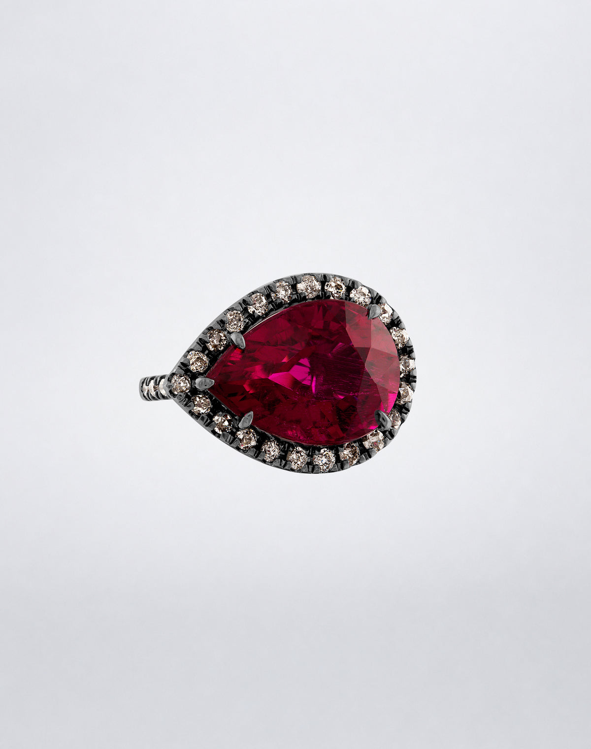 Mindi Mond New York Side Pear Rubellite Ring with rubellite and diamond halo in rhodium-finished 18K blackened gold, angled view.