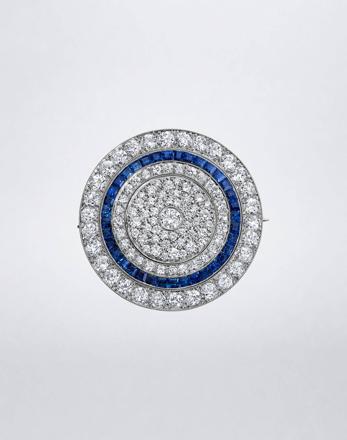 One-of-a-kind Mindi Mond New York RECONCEIVED Celestial Diamond and Sapphire Brooch with concentric rings of diamonds and blue sapphires.
