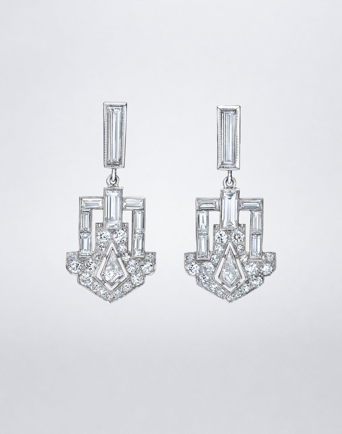 One-of-a-kind Dangling Deco Shield Earrings featuring baguette, round and geometric-cut diamonds arranged in an architectural shield-shaped drop design.