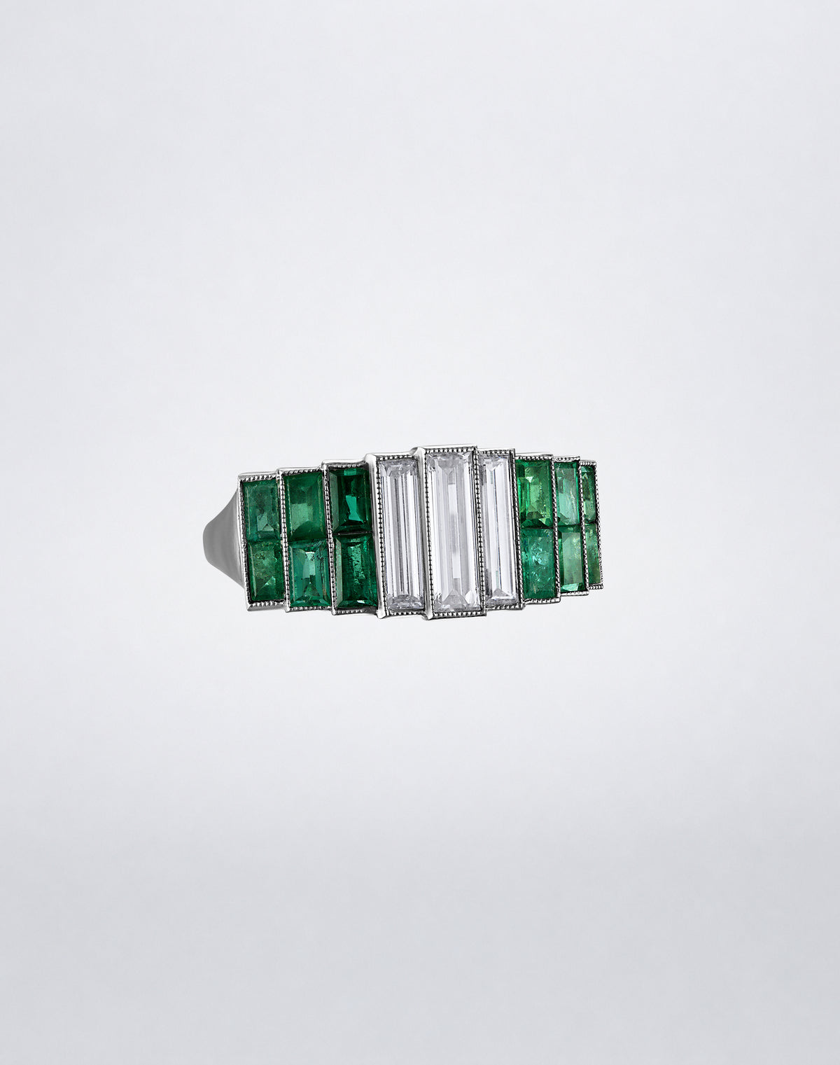 One-of-a-kind Emerald City Band featuring graduated emeralds flanking a central arrangement of elongated baguette diamonds in a geometric platinum metal setting.