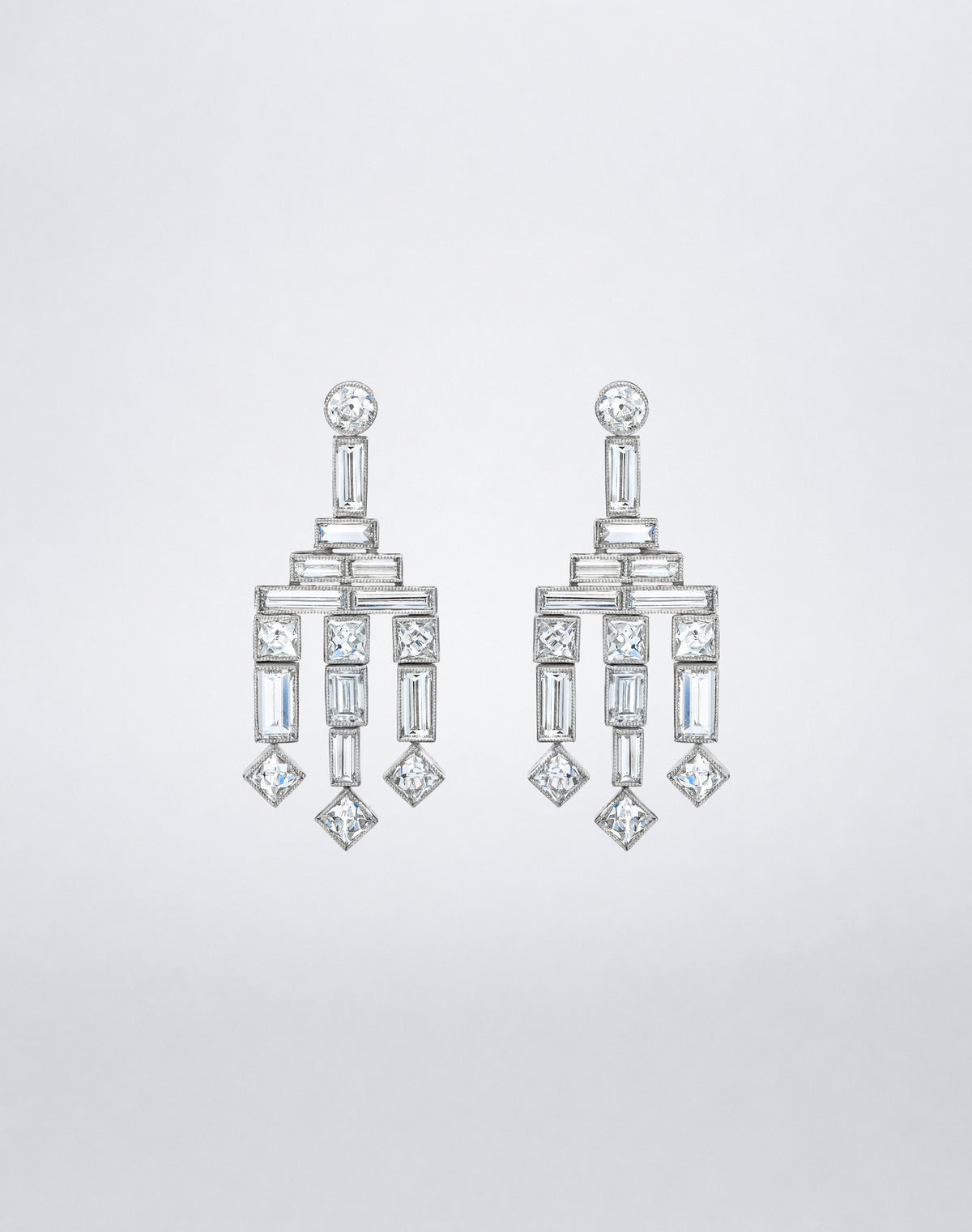 One-of-a-kind Frenchie Chandelier Earrings featuring round diamond studs, geometric arrangements of baguette and square-cut diamonds, and three tiered diamond drops.