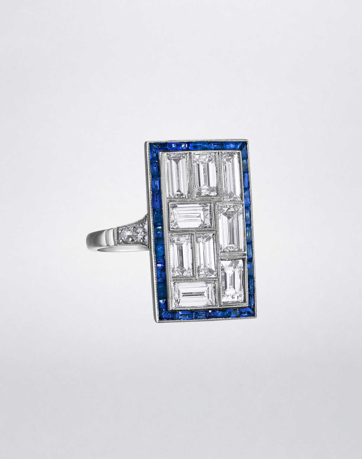 Angled view of the one-of-a-kind Mosaic Platinum Diamond and Sapphire Ring showing the diamond mosaic, blue sapphire border and platinum setting.