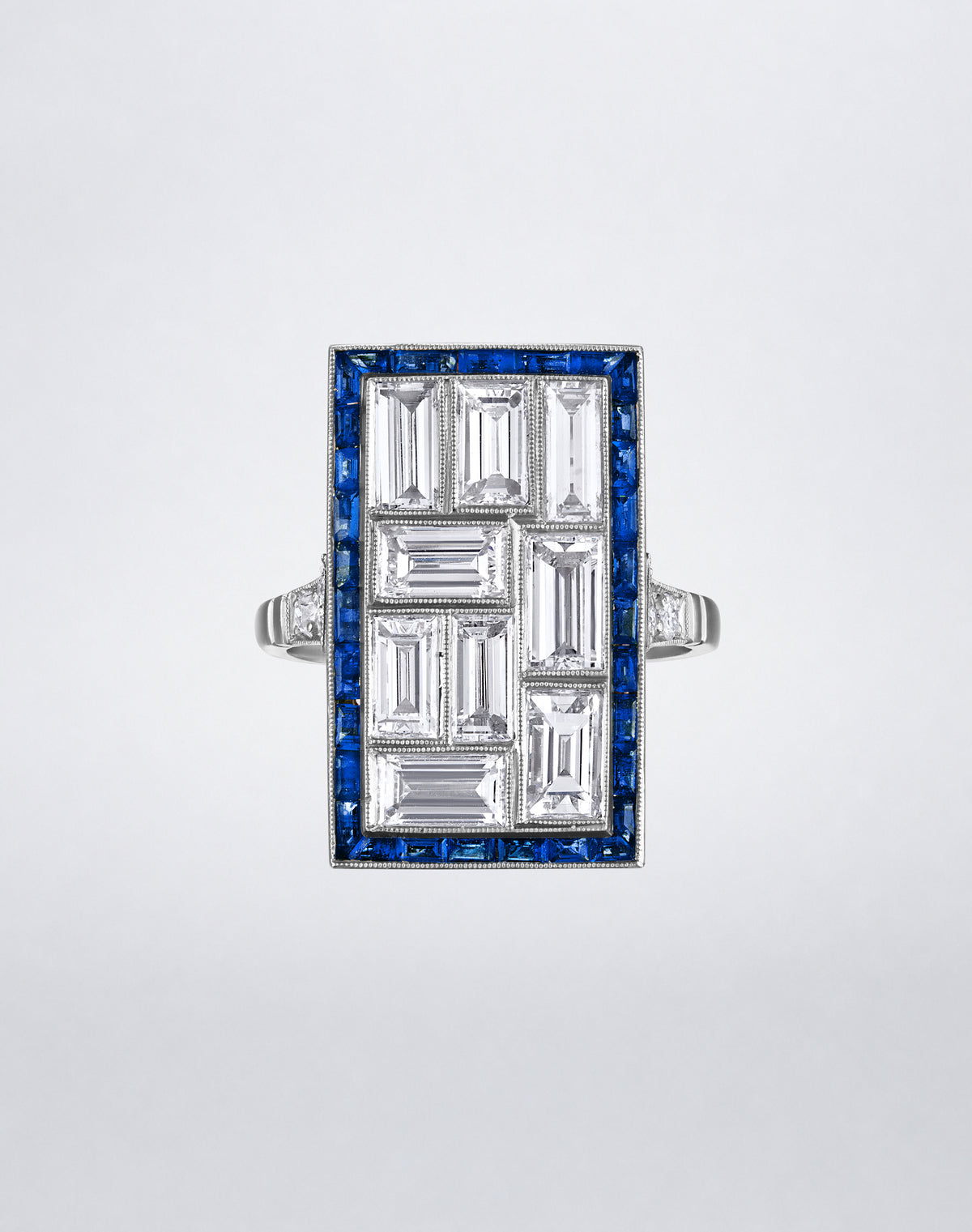 One-of-a-kind Mosaic Platinum Diamond and Sapphire Ring featuring a geometric arrangement of rectangular diamonds framed by vivid blue sapphires.
