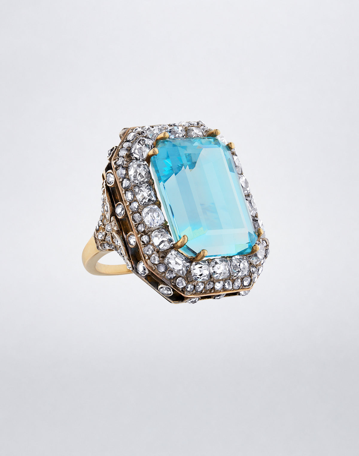 Angled view of the one-of-a-kind Octagonal Aquamarine Ring showing the step-cut aquamarine and mixed antique-cut diamond surround in a Victorian mount.