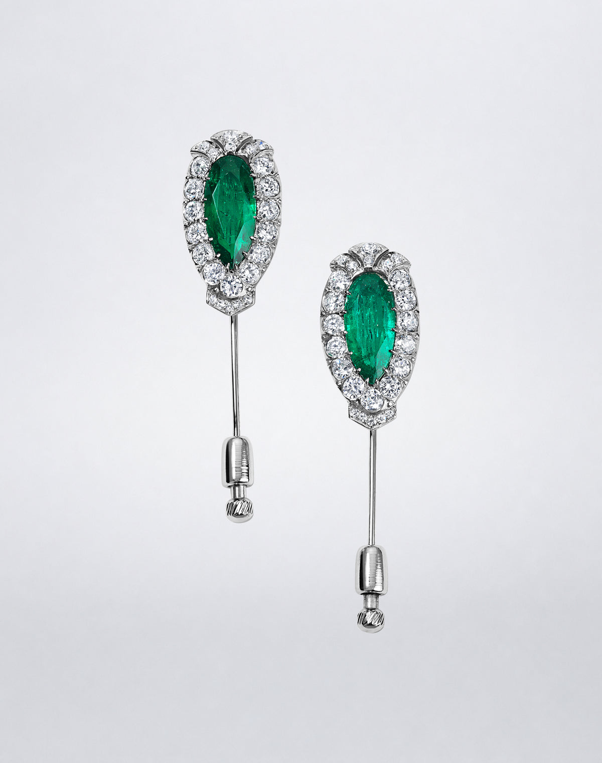 One-of-a-kind Mindi Mond New York Twin Colombian Emerald Pins in platinum, each featuring a Colombian emerald framed by diamonds.
