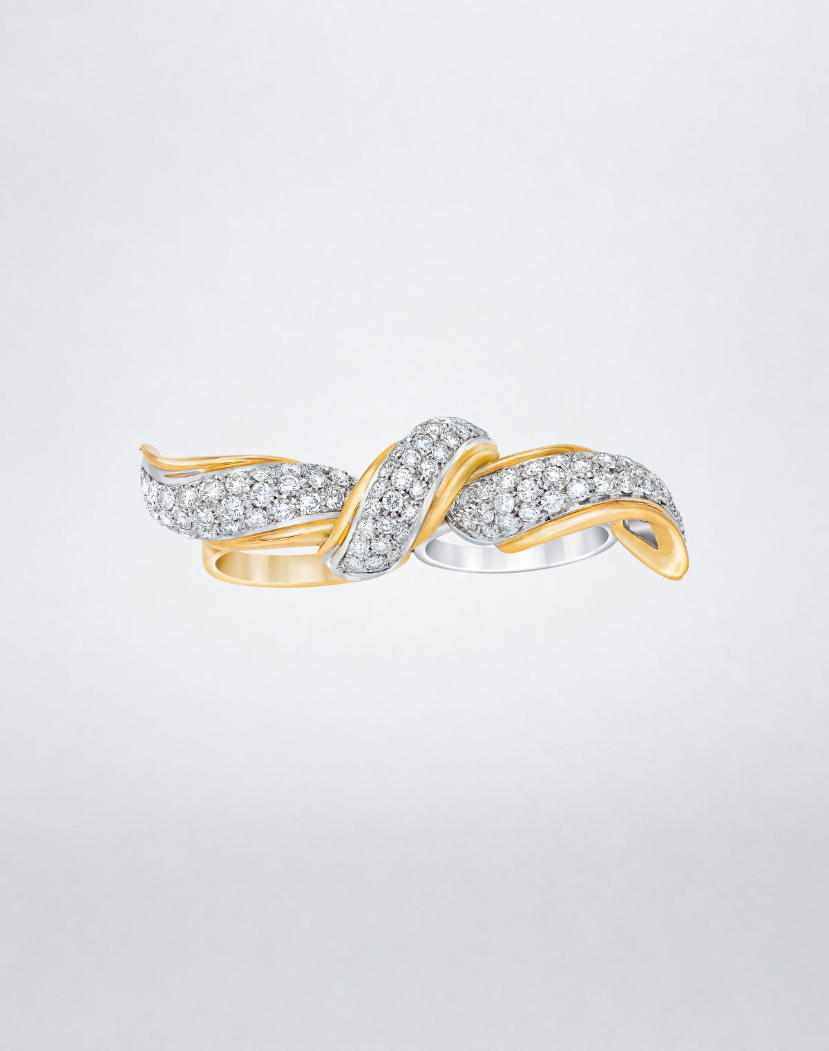 One-of-a-kind Two Finger Bow Ring featuring an intertwined bow motif set with round diamonds in contrasting yellow and white gold.