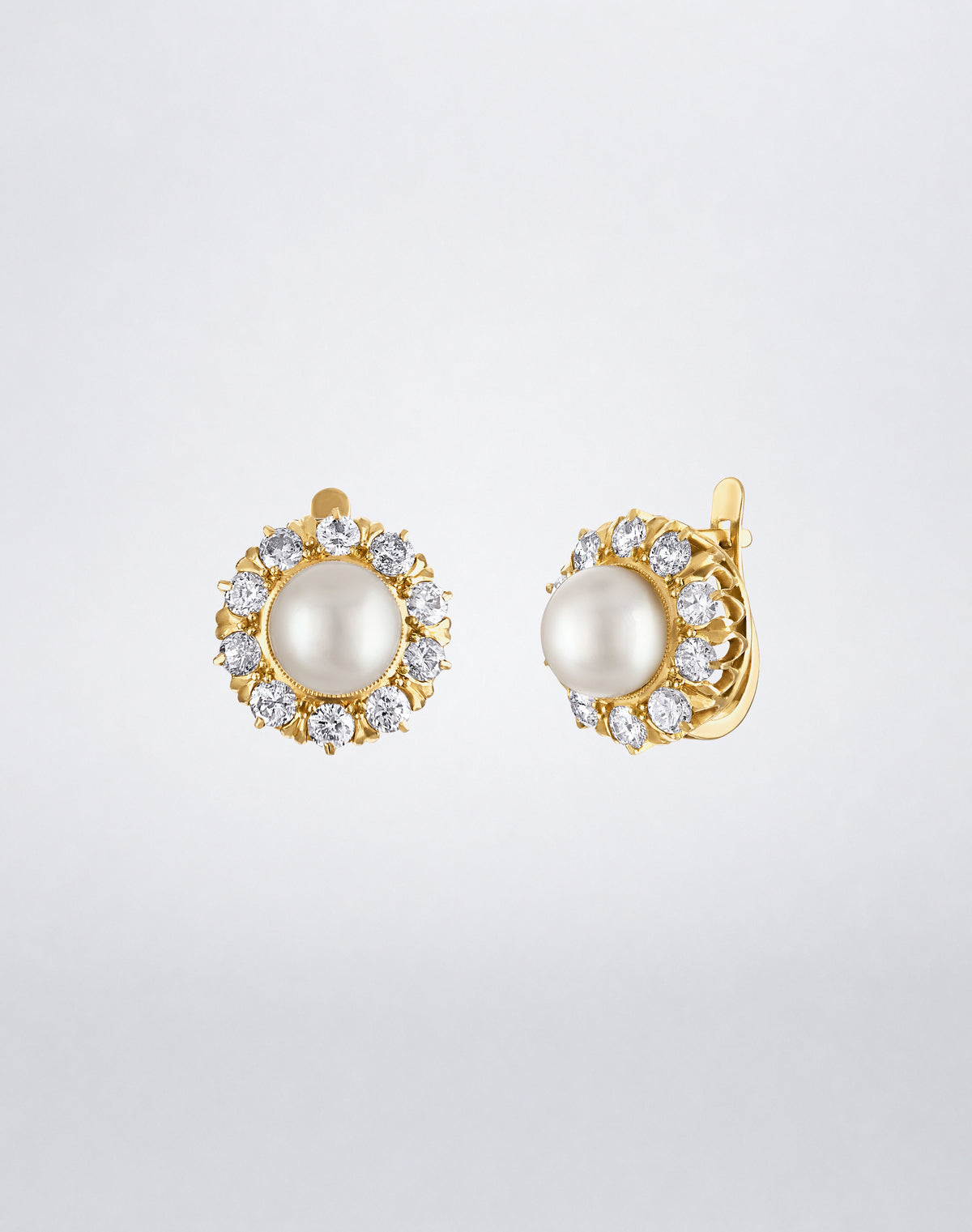 One-of-a-kind Victorian pearl and old European diamond earrings featuring central white pearls encircled by old European-cut diamonds in yellow gold, side view, with leverbacks